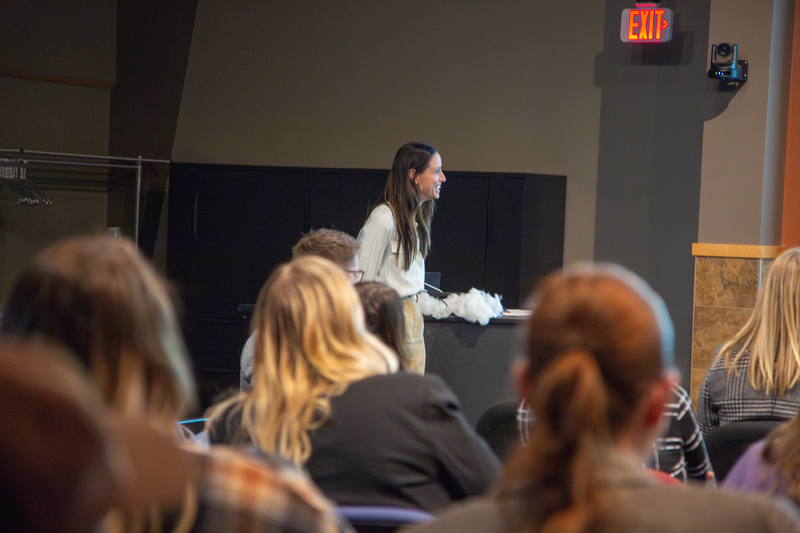 Jamie Hegge speaking on stage to a room full of people. 