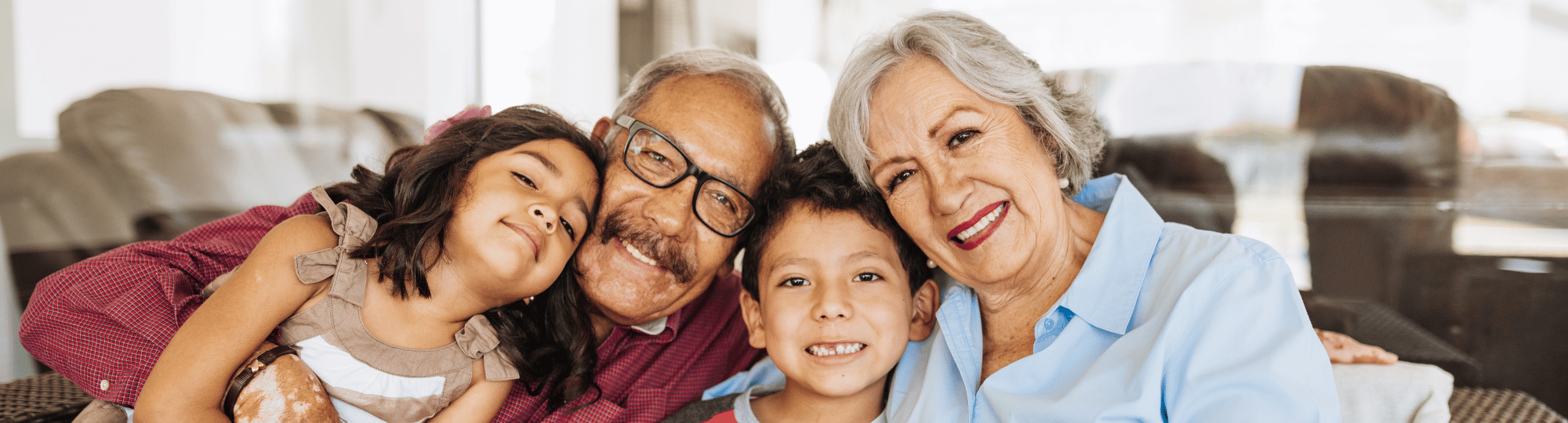 Close up group photo with two grandparents and two grandchildren hugging.